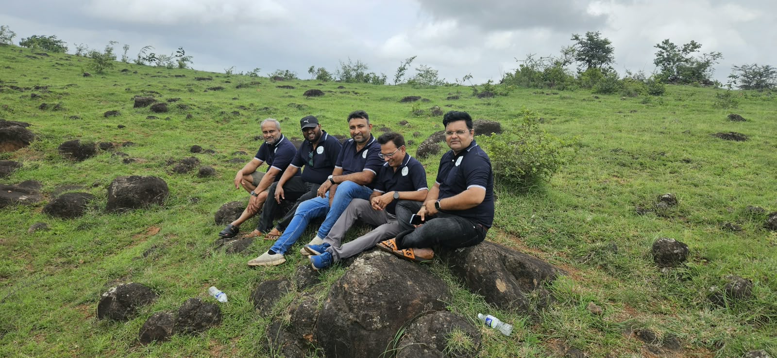 Shwas Foundation team members sitting together on a green hillside